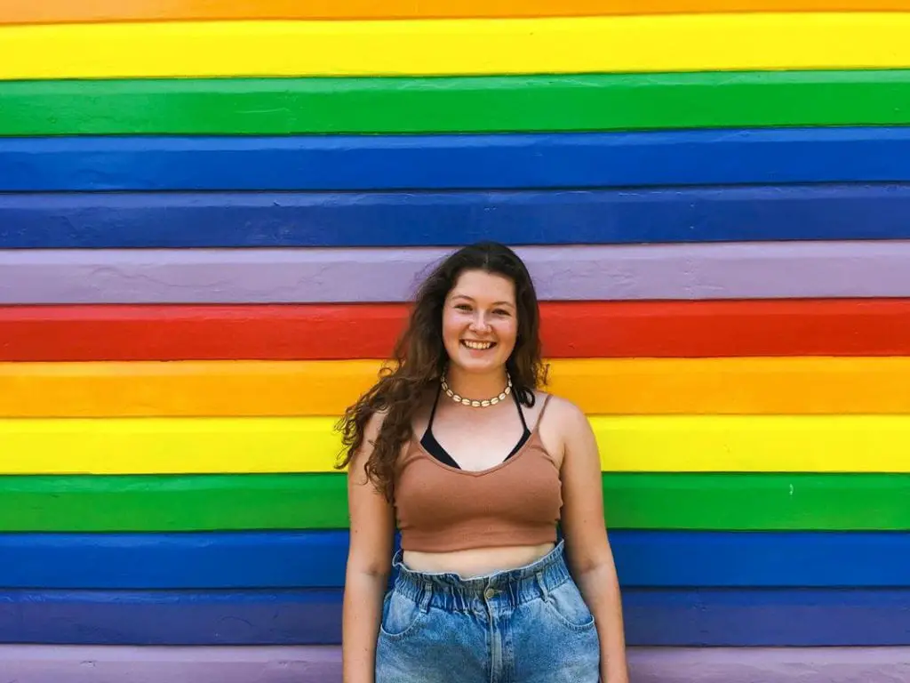 solo female traveller in front of rainbow house in Nimbin, Australia