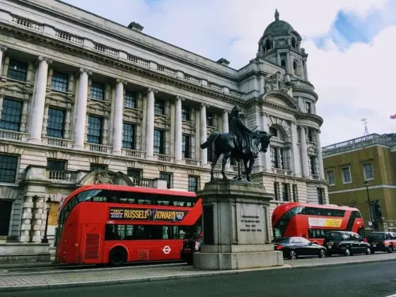 Red London buses driving past the banqueting house in January 2020