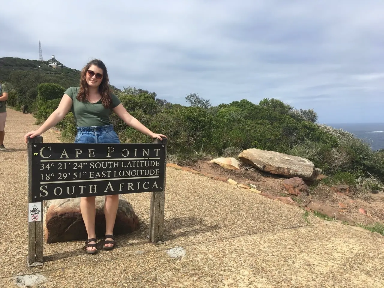 Girl standing at Cape Point sign in South Africa