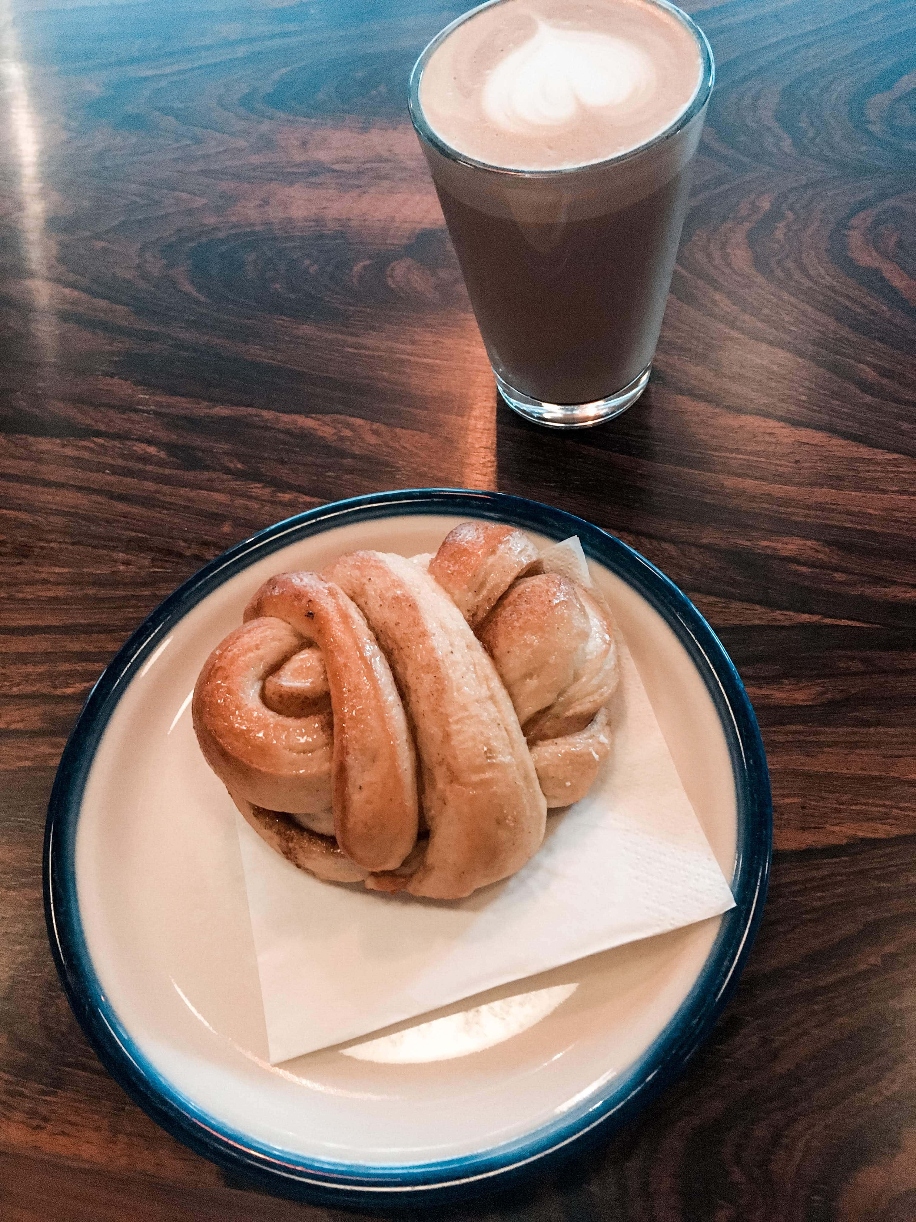 Latte and cinnamon bun at a cafe in Oslo Norway