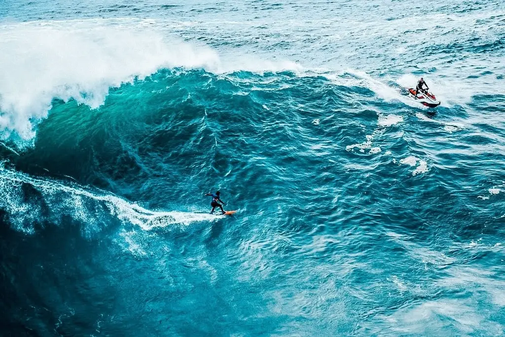 surfing huge and big waves in Nazare, Portugal