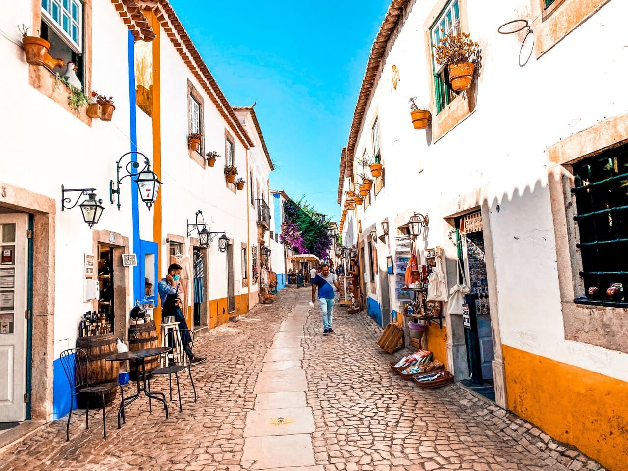 A street in the medieval village area of Óbidos, one of the oldest towns of Portugal. The buildings are white, blue and gold.