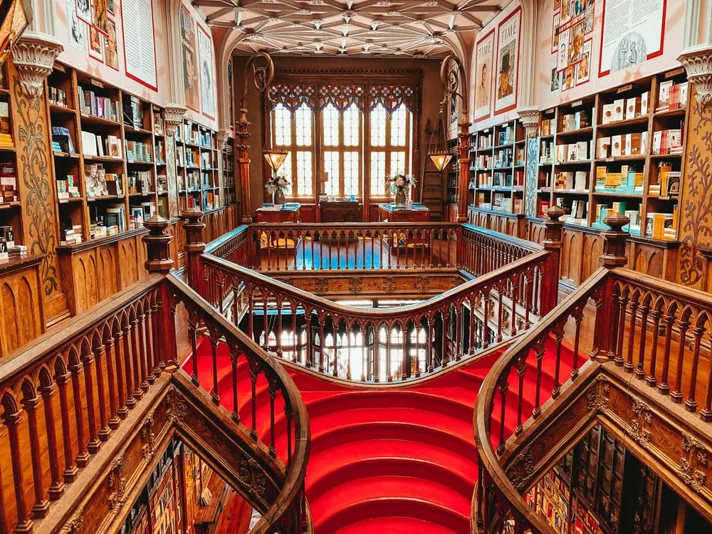 Interior of the Livraria Lello bookshop in Porto Portugal. This was apparently the inspiration behind the library at Hogwarts from Harry Potter, and is famous for its iconic red stairacase seen in this photo.