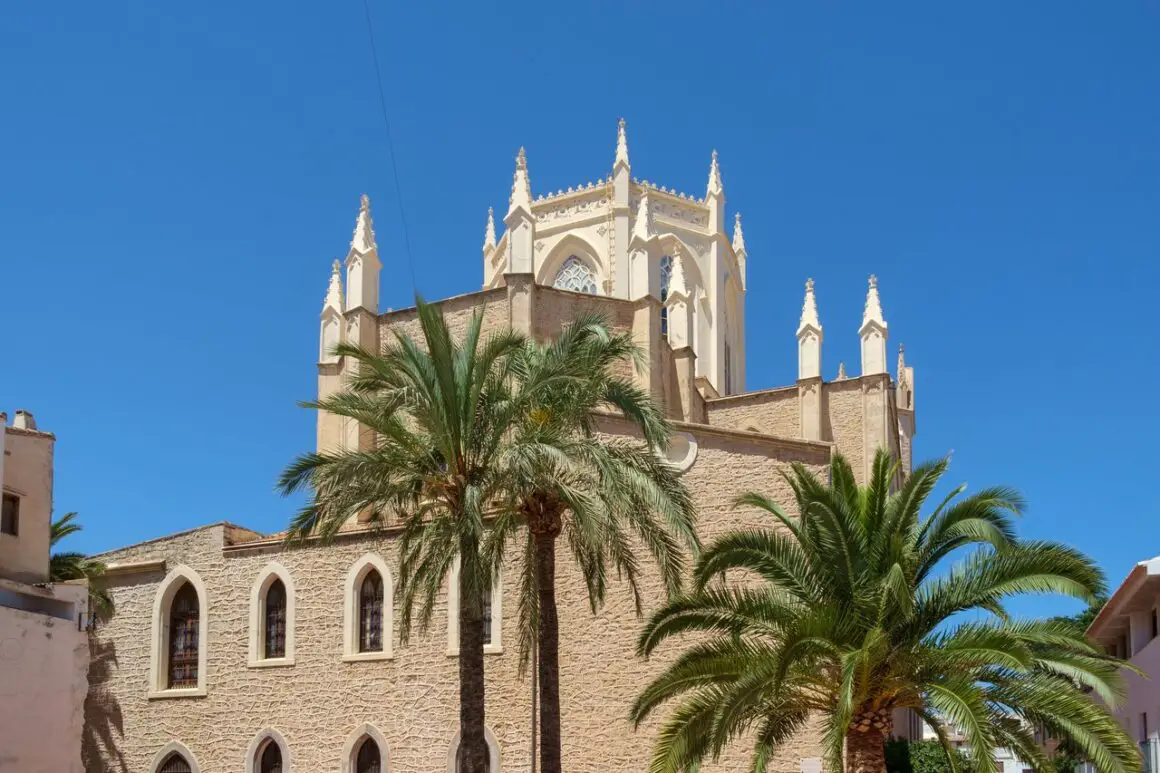 Benissa Church in the Costa Blanca, with palm trees in front of the building.
