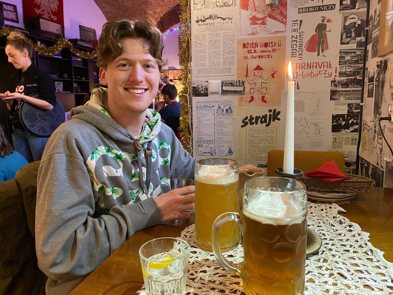 Man smiling holding a 1 litre glass of beer in Konspira restaurant Wroclaw. The beer prices in Poland are some of the cheapest in Europe.