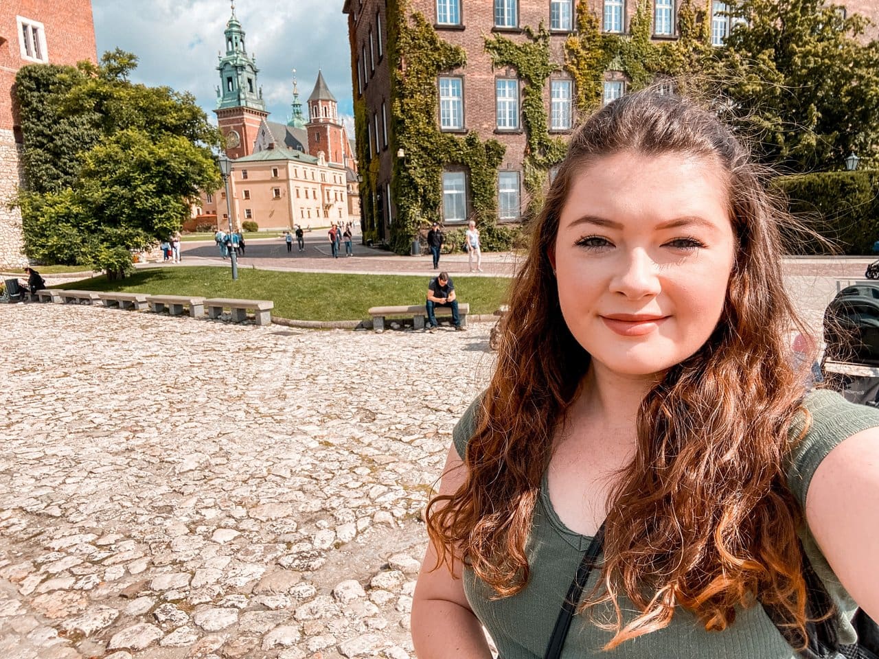 Ella at the Krakow Castle in autumn. It's very easy to keep your travel costs low in Krakow since there are so many free things to do, making Krakow cheap to visit.