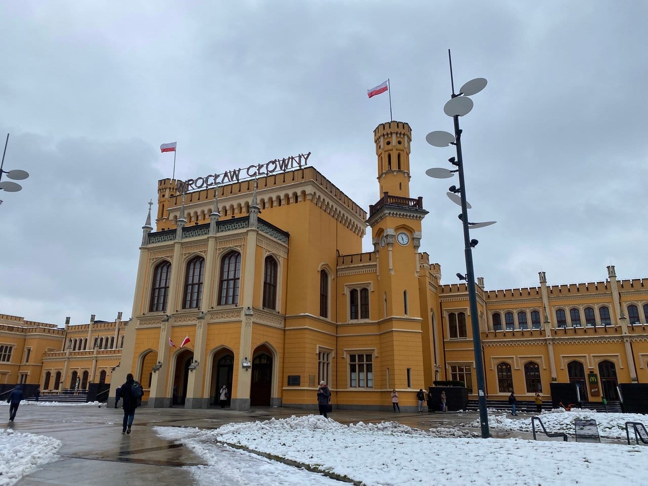 The yellow exterior of Wroclaw Train Station on a winter's day.