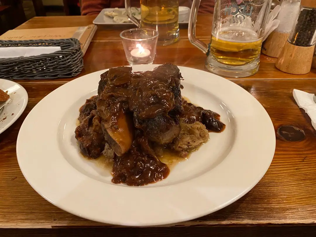 Hearty Polish meal of Pork knuckle served over potatoes in a traditional Poznan restaurant.