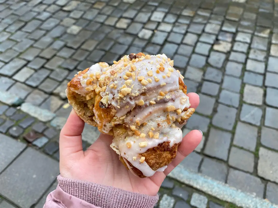 A close-up of a traditional St Martins Croissant held in hand, symbolizing the culinary delights visitors can savour during their day trip to Poznan.