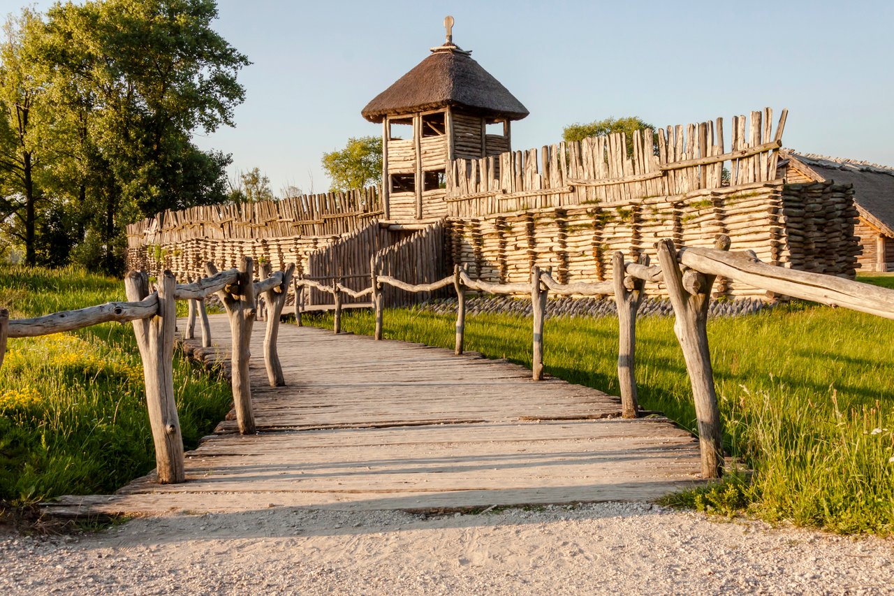 A wooden watchtower and reconstructed fortifications of the Biskupin archaeological site, a unique outdoor museum experience easily reached on a day trip from Poznan, Poland.