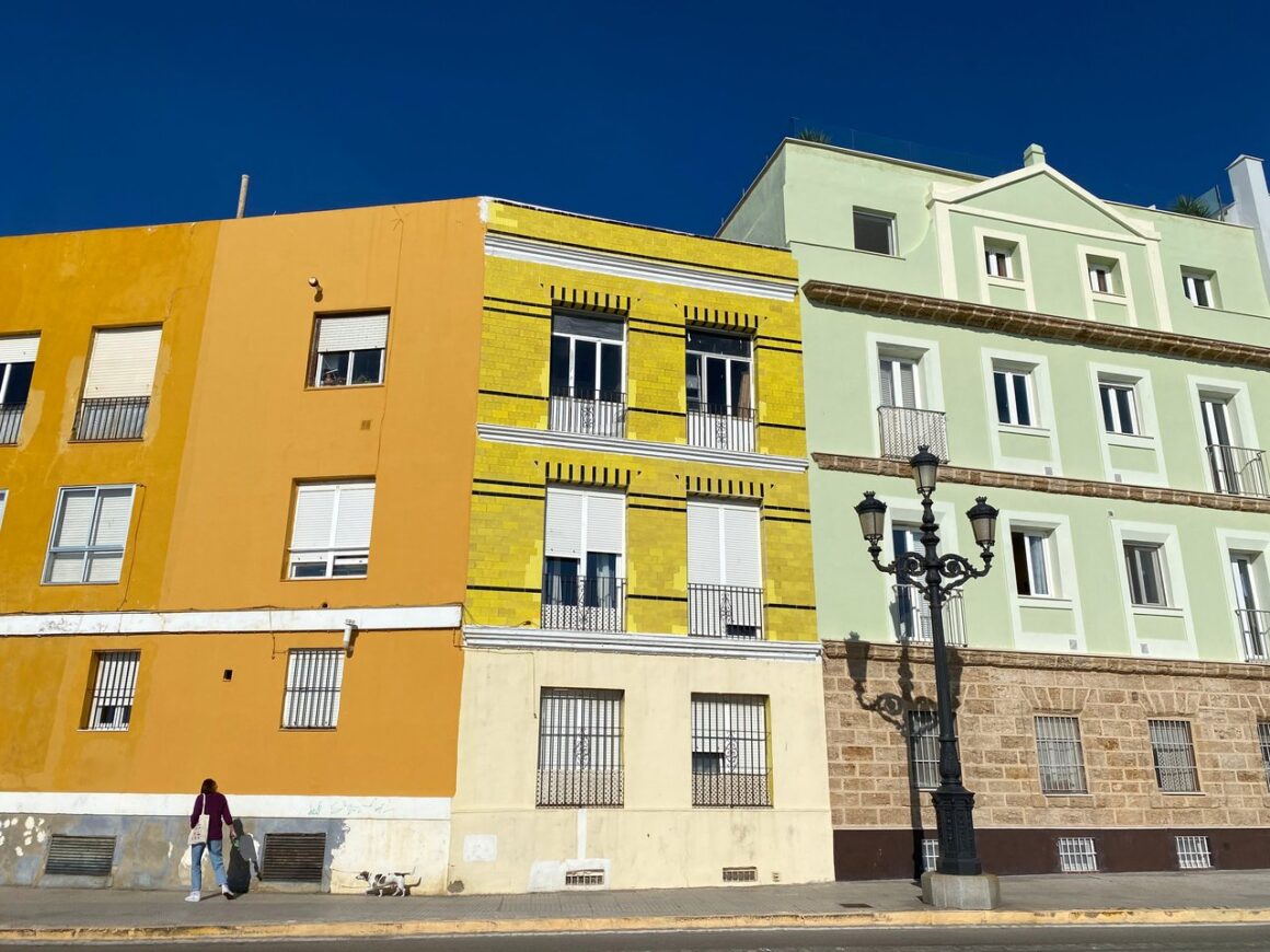 Colourful buildings painted with yellow, orange and green in the La Viña neighbourhood of Cadiz