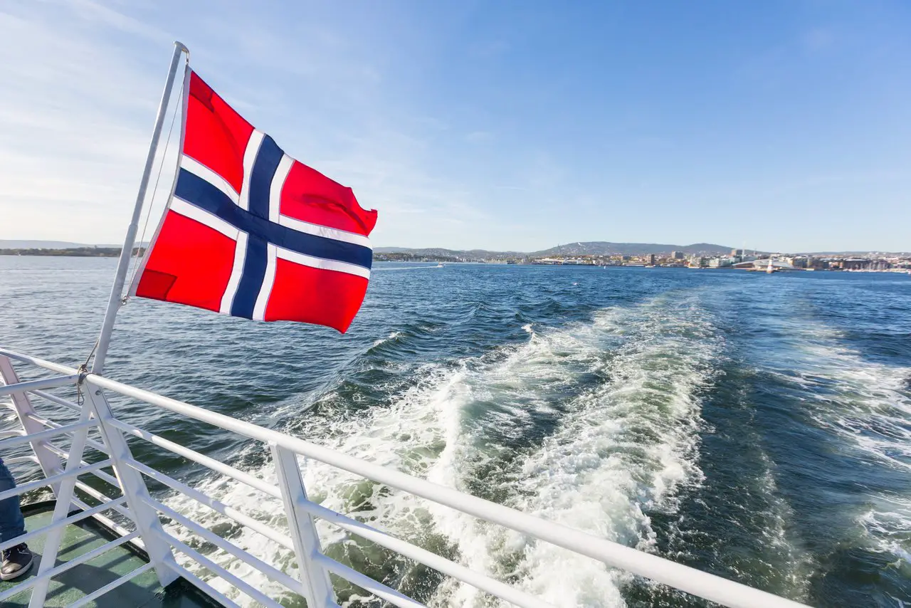 Norwegian flag fluttering off the back of a boat in the Oslo Fjord