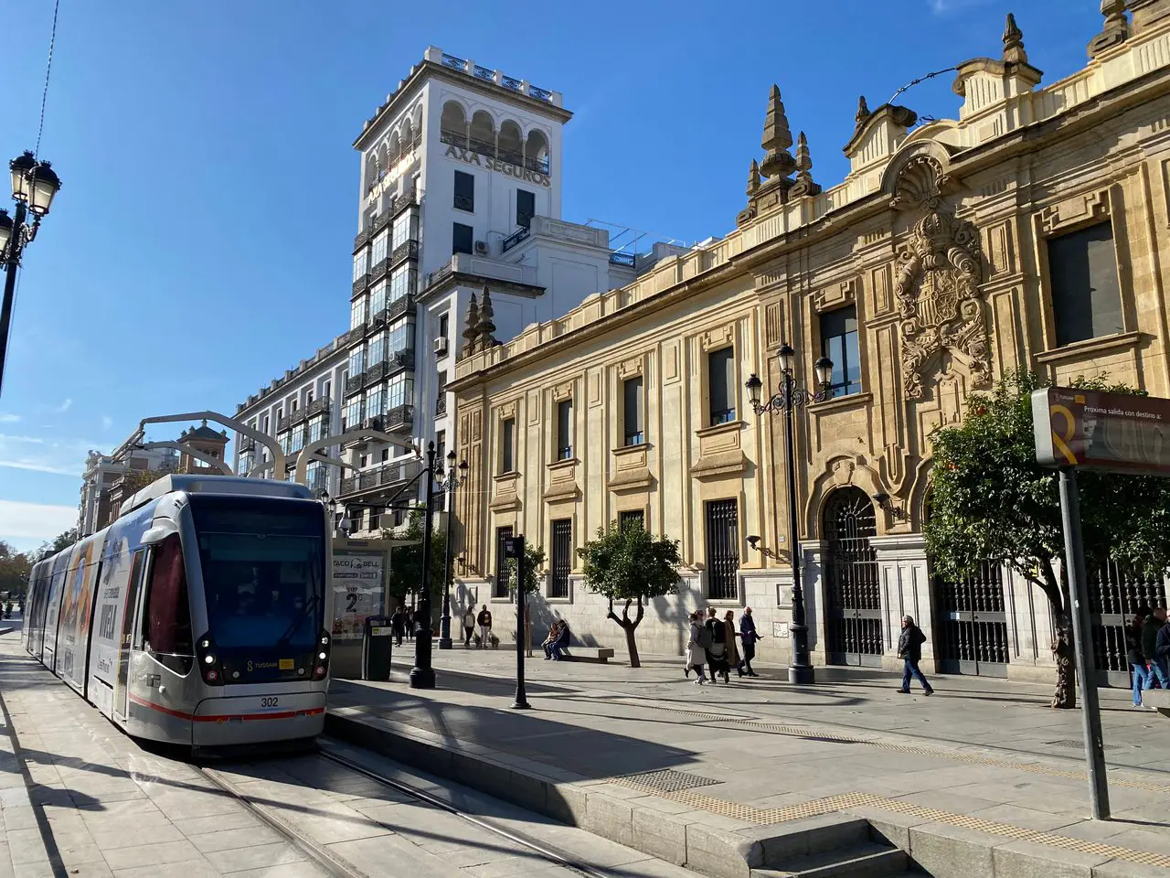 A tram drives in front of some buildings in Seville.