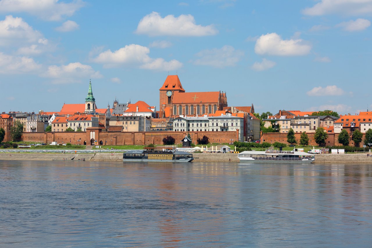 The picturesque skyline of Torun, viewed from across the Vistula River, with its historic Gothic buildings and churches, offers a culturally rich day trip destination from Poznan.
