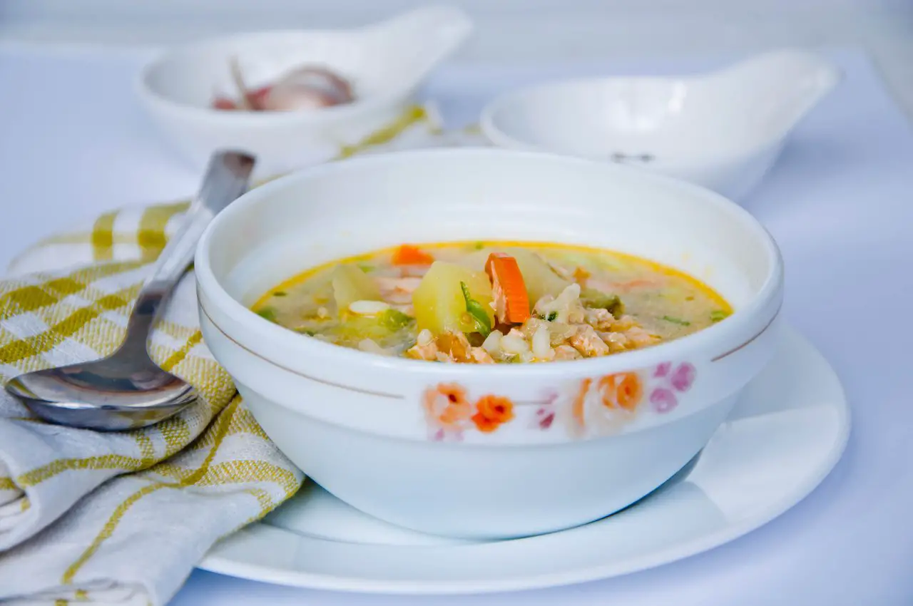 Bowl of traditional Norwegian soup with salmon and vegetables
