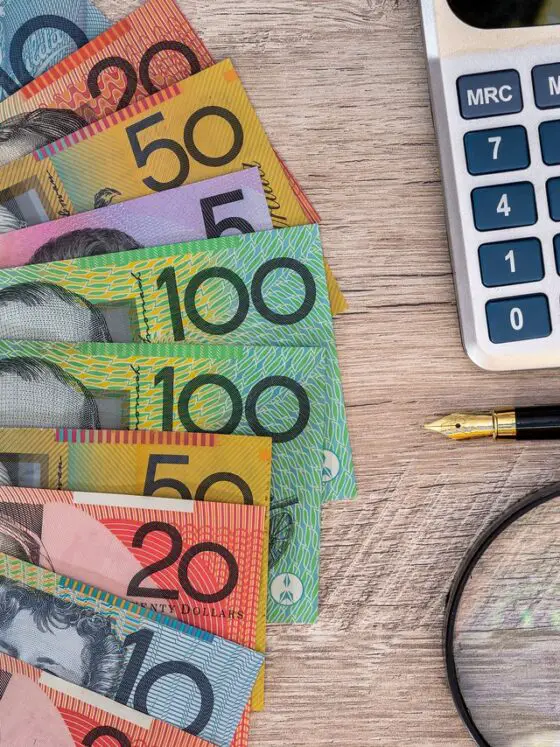 Australian dollars with calculator, pen and magnifier