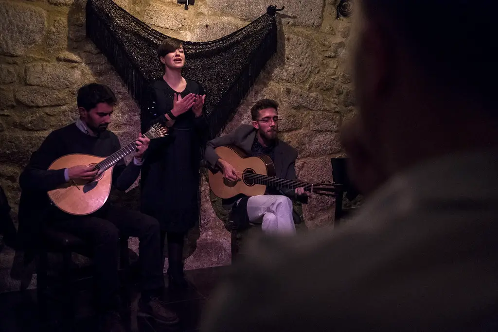Porto fado live performance featuring two male guitar players and a female singer
