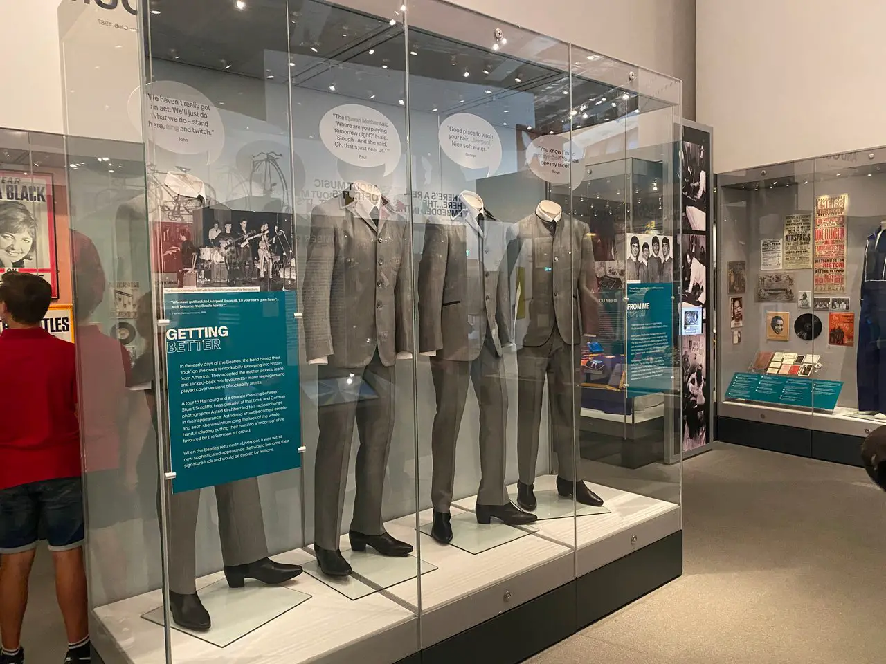 Display case inside the Museum of Liverpool showing grey suits worn by The Beatles