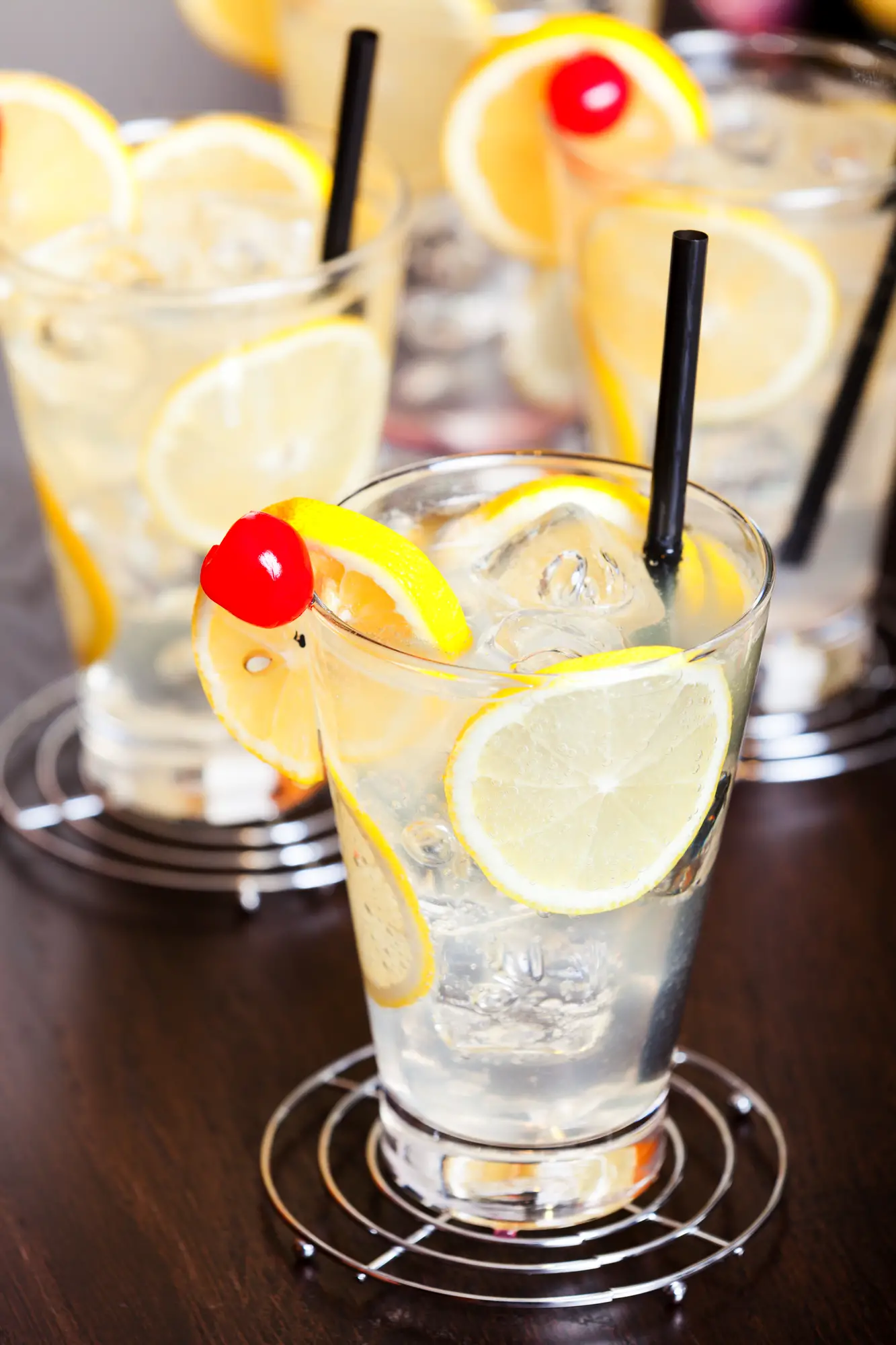 four glasses of Tom Collins cocktail at a bar