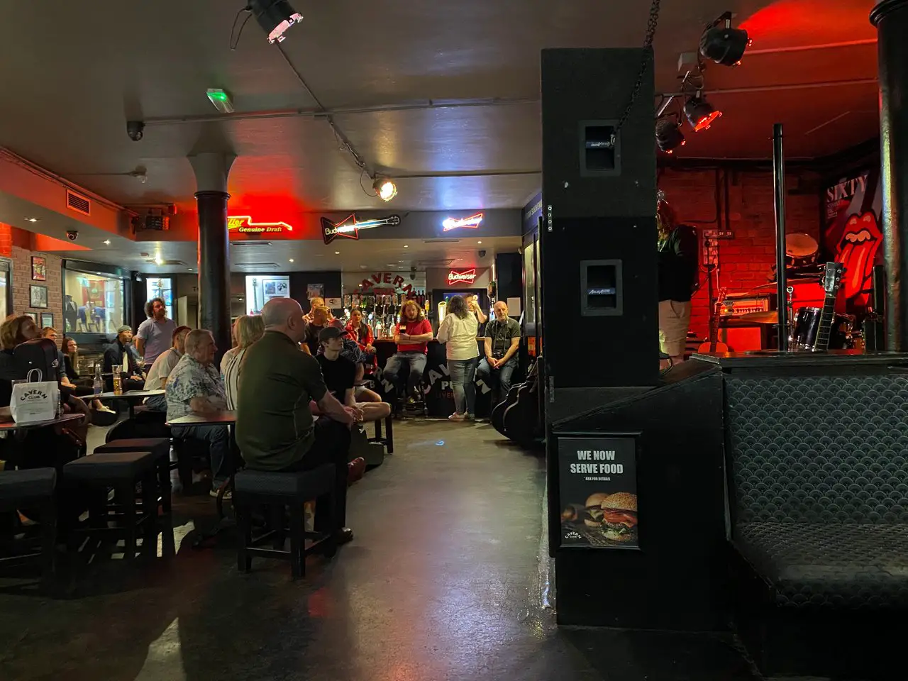 Inside the Cavern Pub in Liverpool on Monday Open Mic night. The pub is around half-full, and a man is standing on the stage. Liverpool's nightlife goes on all week long.