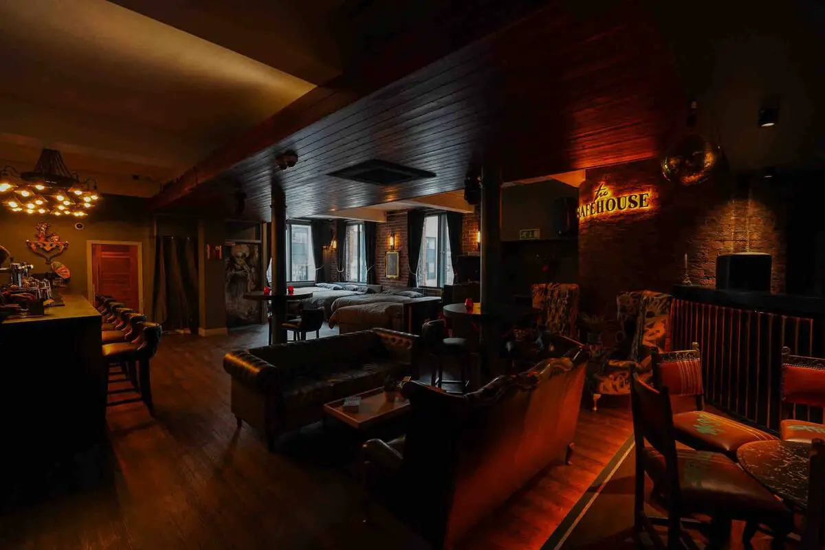 Dimly-lit and plush interior of the speakeasy apartment in Liverpool showing leather sofas and exposed brick. This is one of the best hen apartments in Liverpool.