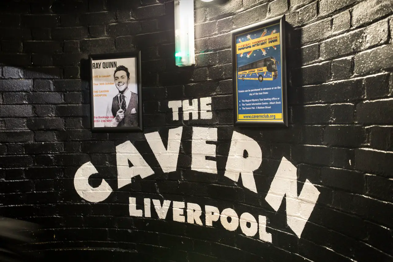 Entrance to the famous Cavern Club in Liverpool, showing the Cavern sign against a black wall.