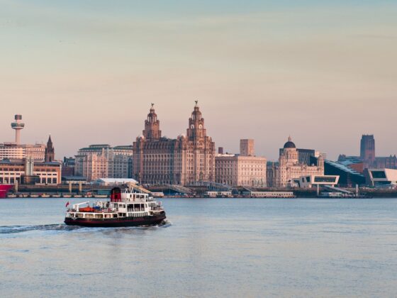 The Mersey Ferry sailing along the River Mersey with Liverpool at dusk in the background - you can see the Liver building and Museum of Liverpool in the background