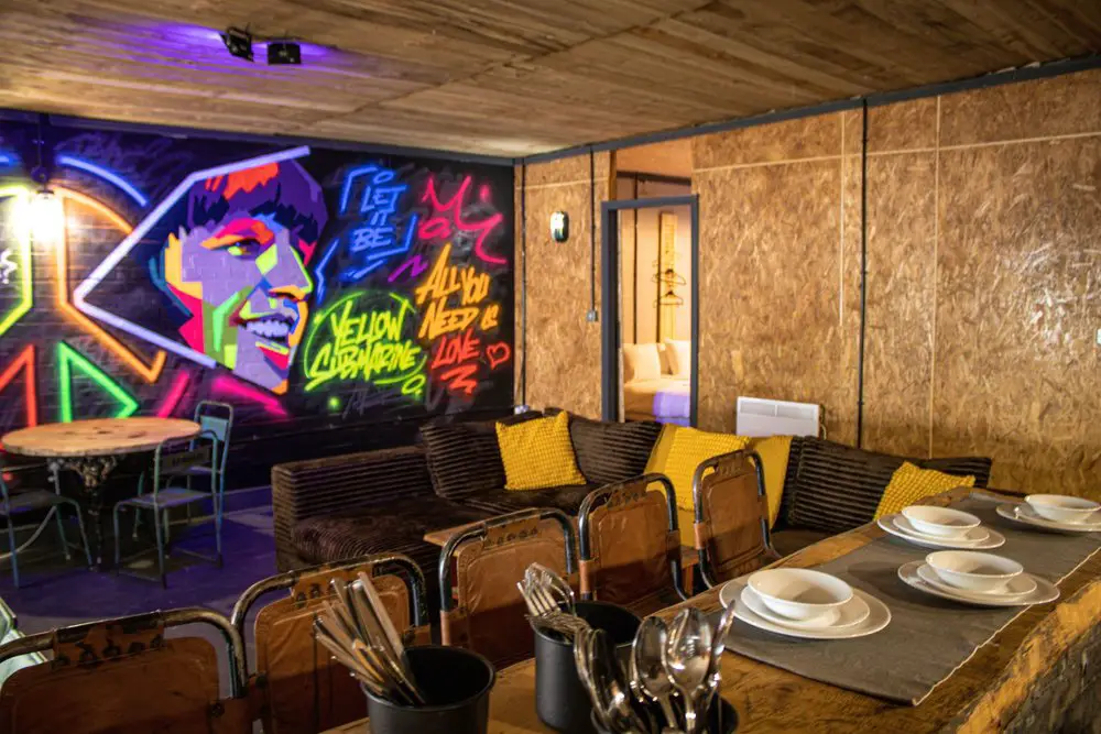 Graffiti wall behind a large table in a large living room. This is one of the top party apartments for a one night stay in Liverpool
