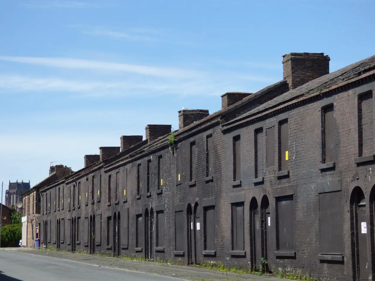 Derelict terraced houses on Powis Street in Toxteth, Liverpool painted black for use as a set for the TV series Peaky Blinders. You can visit this street on Liverpool Peaky Blinders bus tours.