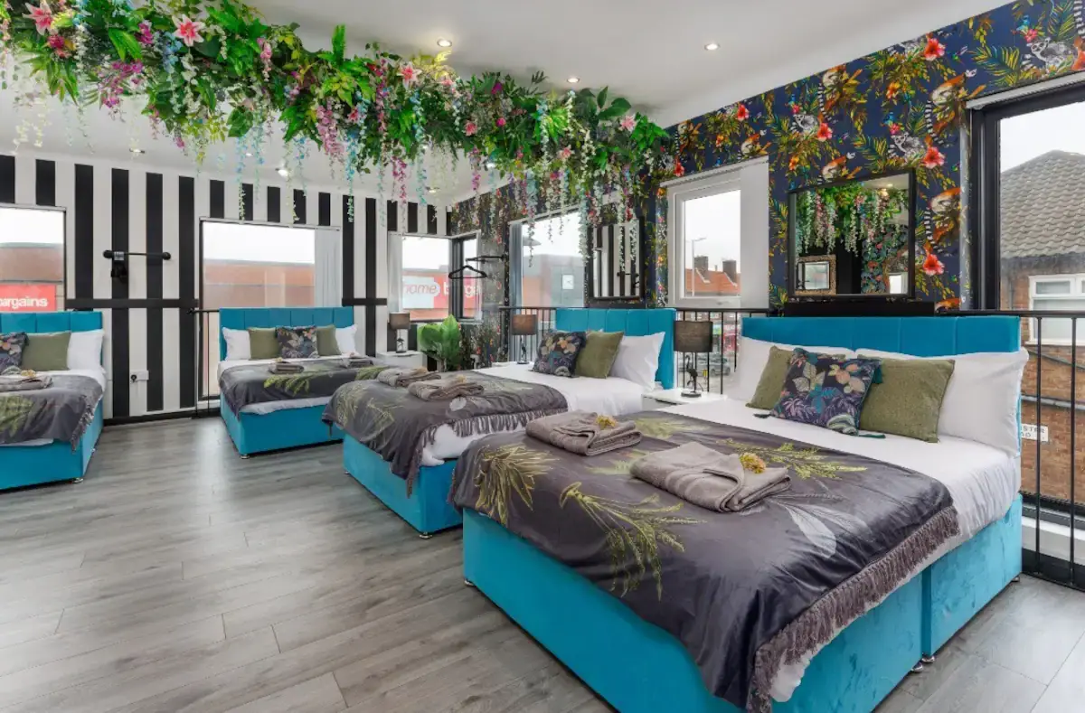 Large girly bedroom with numerous beds and floral decor. This is the perfect Liverpool party pad for hen dos