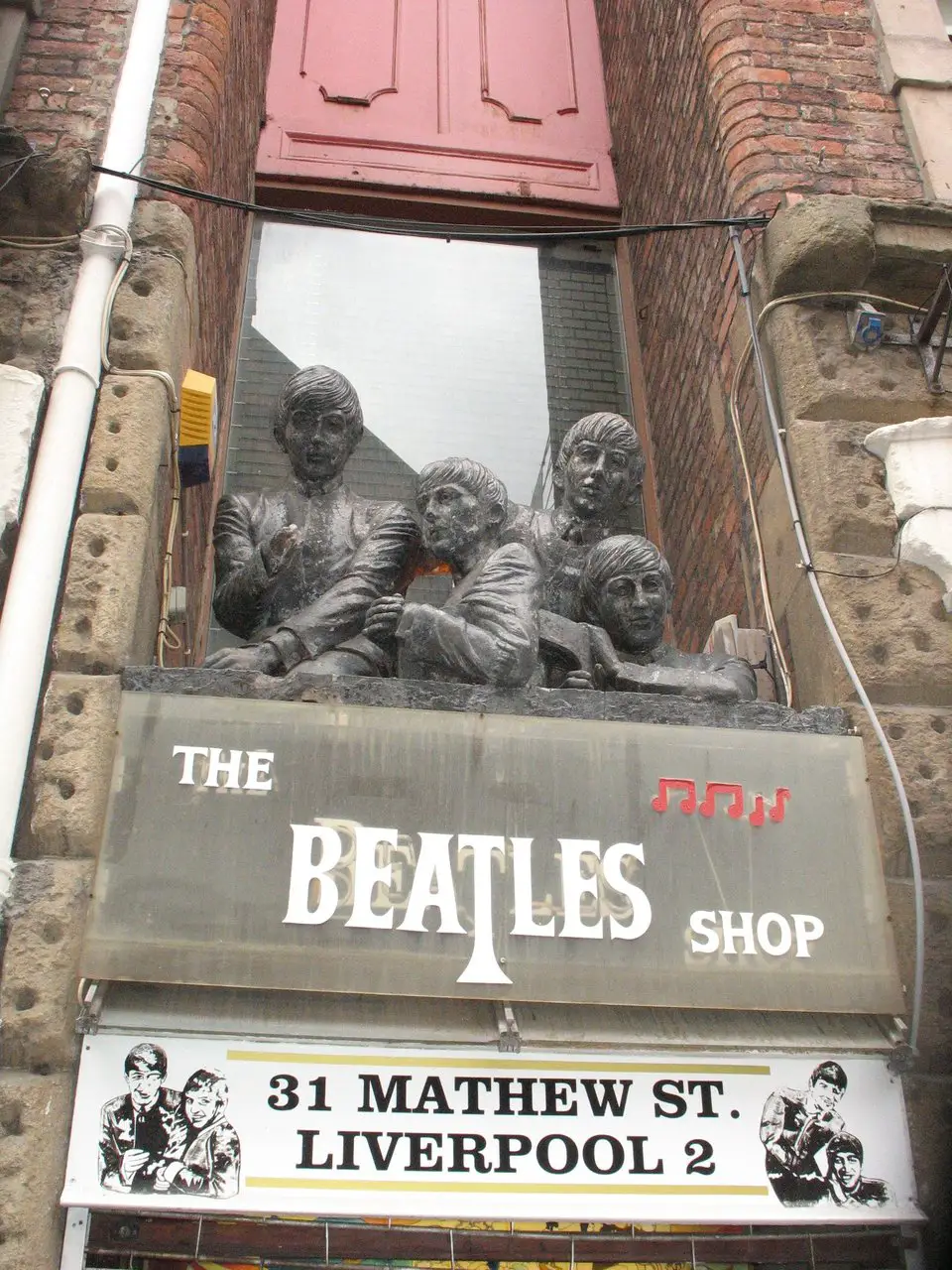From Us To You Beatles statue above the Beatles Shop Liverpool. This is one of the lesser-known Liverpool Beatles sculptures.