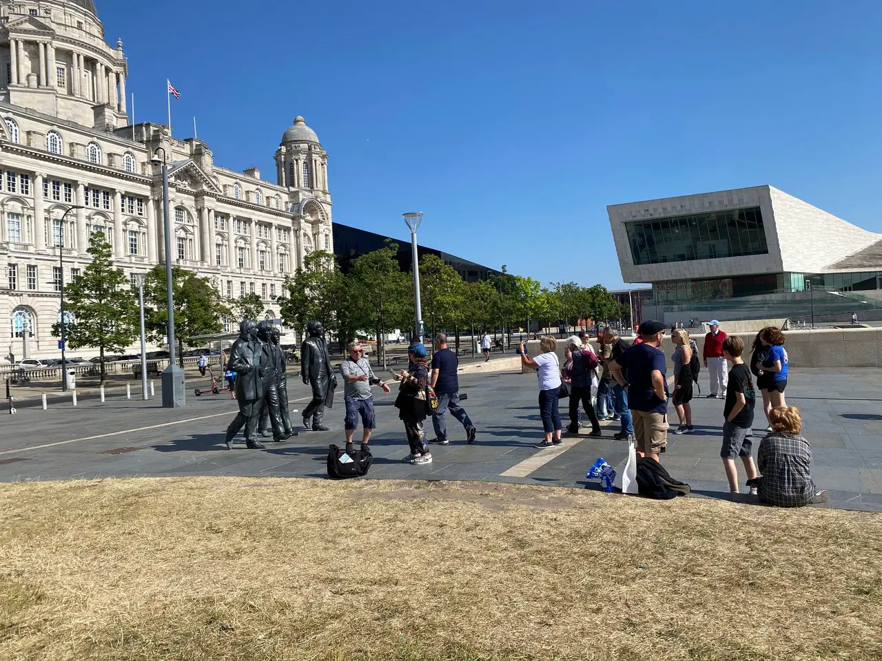 Tourist crowds at Beatles Statue Liverpool on a sunny day